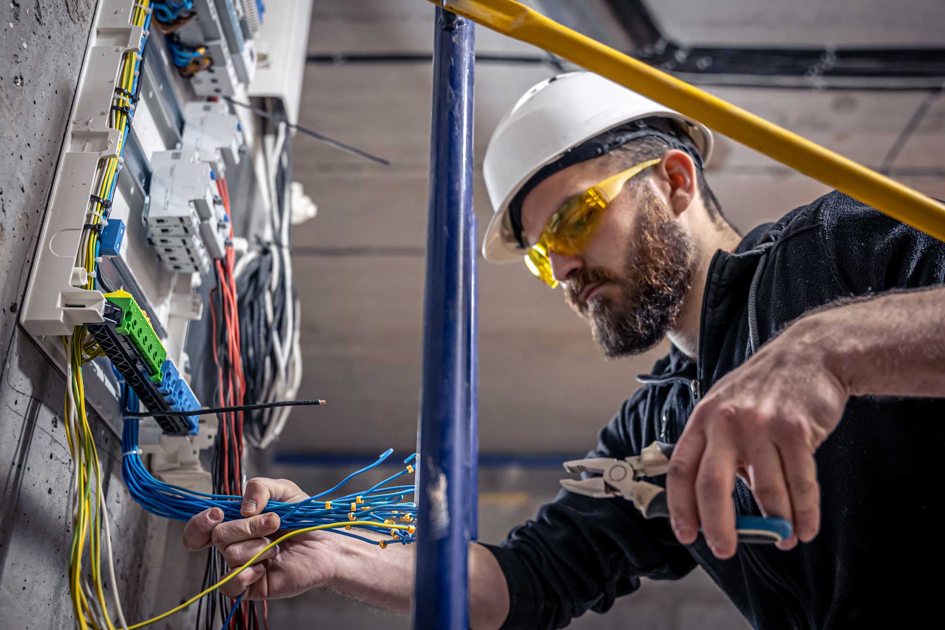 a male electrician works in a switchboard with an ZLWKBE5